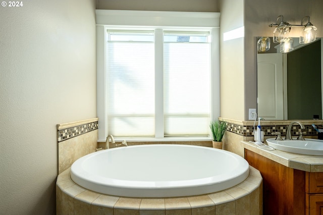 bathroom with vanity and tiled tub