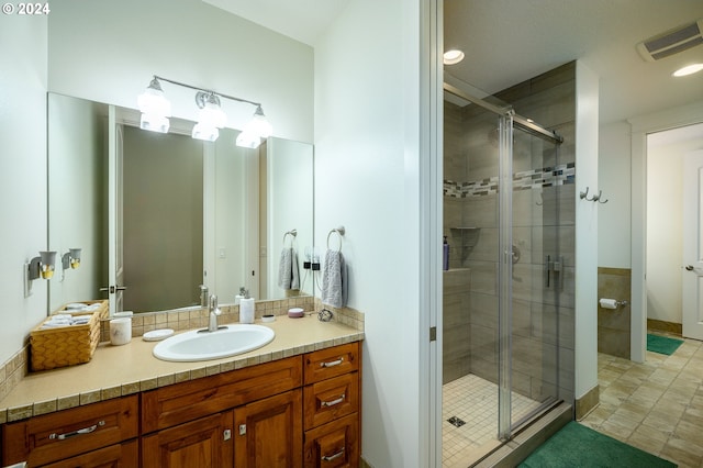 bathroom with vanity and a shower with shower door