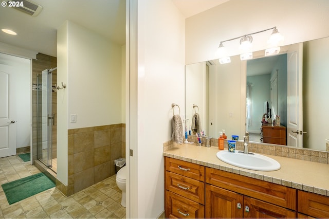 bathroom featuring vanity, toilet, and walk in shower