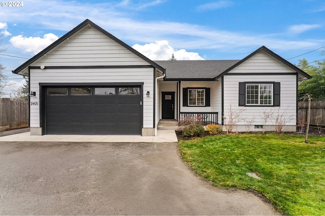 view of front of property with a garage, covered porch, and a front lawn