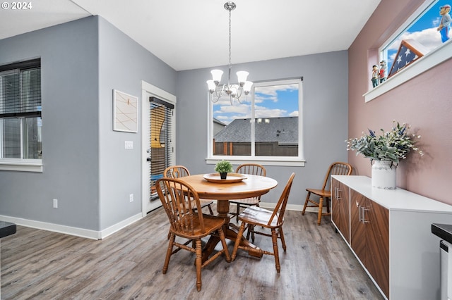 dining area with an inviting chandelier and light hardwood / wood-style floors