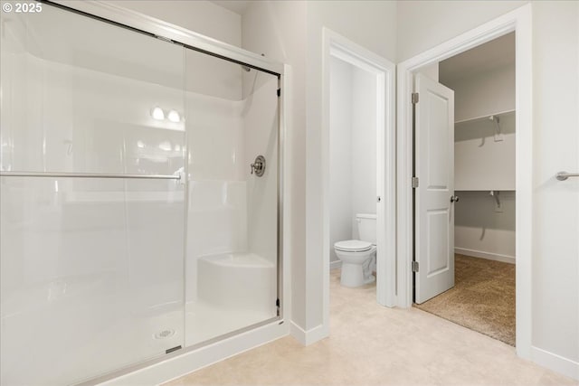 bathroom featuring walk in shower and toilet