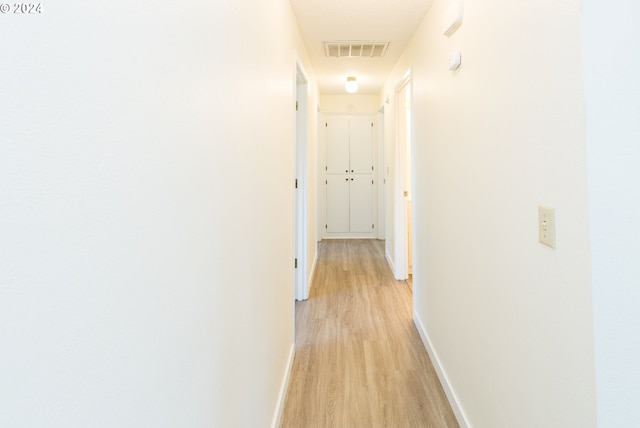 corridor with light hardwood / wood-style floors