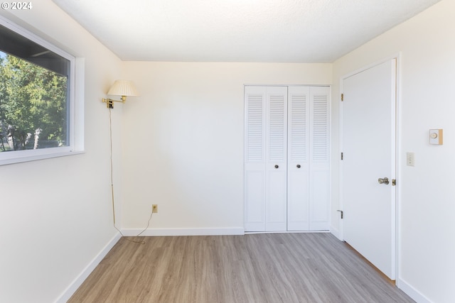 unfurnished bedroom featuring light hardwood / wood-style floors and a closet