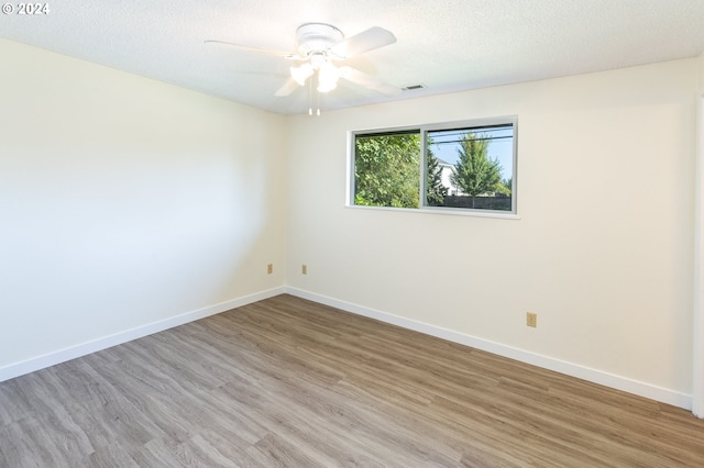 empty room with ceiling fan, a textured ceiling, and light hardwood / wood-style flooring