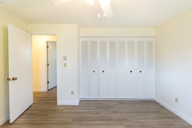 unfurnished bedroom featuring hardwood / wood-style flooring, a closet, and a textured ceiling