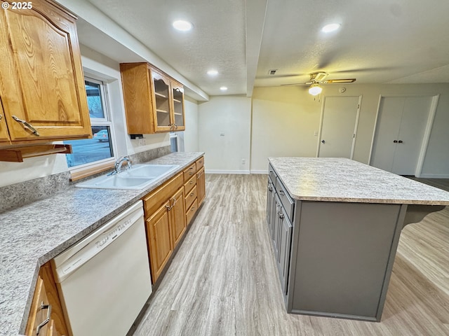 kitchen featuring a kitchen island, sink, white dishwasher, a textured ceiling, and light hardwood / wood-style flooring