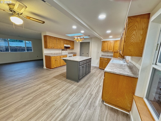 kitchen with white electric range, sink, light hardwood / wood-style flooring, a kitchen island, and ceiling fan