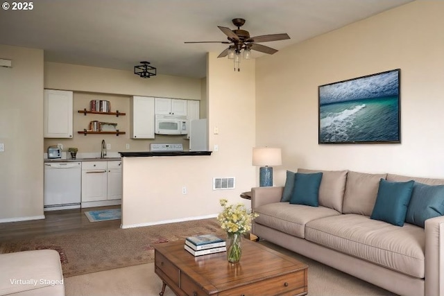 carpeted living room with sink and ceiling fan