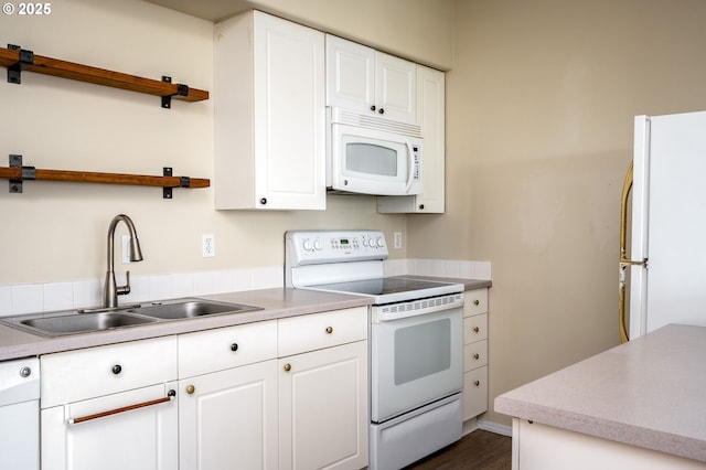 kitchen with white cabinetry, sink, and white appliances