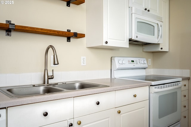 kitchen with white cabinetry, white appliances, and sink