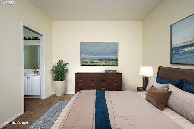 bedroom with sink, light colored carpet, and ensuite bathroom