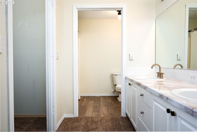 bathroom featuring vanity, hardwood / wood-style floors, and toilet