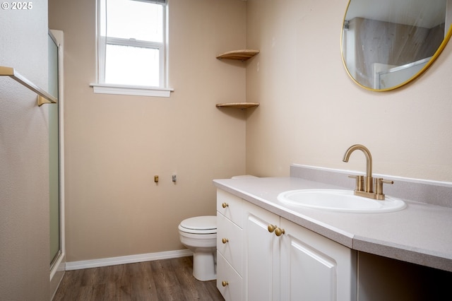 bathroom featuring vanity, hardwood / wood-style floors, a shower with shower door, and toilet