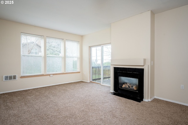 unfurnished living room featuring carpet flooring and a fireplace