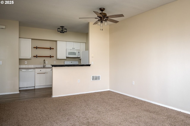 kitchen with dark colored carpet, white appliances, ceiling fan, and white cabinets