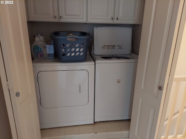 washroom with washer and clothes dryer, cabinets, and light tile patterned floors