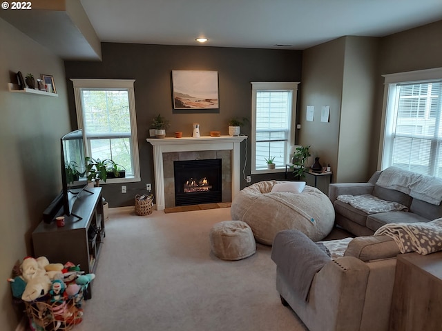 living room with carpet flooring and a tiled fireplace