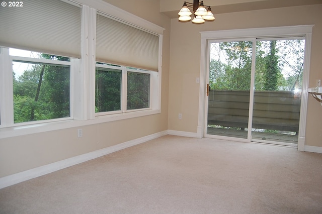 unfurnished room featuring carpet floors and a notable chandelier