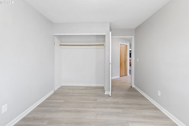 unfurnished bedroom featuring a textured ceiling and a closet