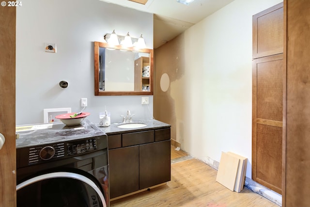 bathroom featuring hardwood / wood-style flooring, vanity, and washer / dryer