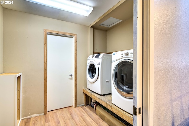 washroom with light hardwood / wood-style flooring and independent washer and dryer