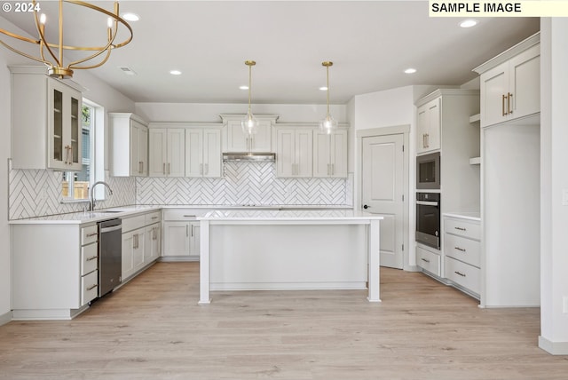 kitchen featuring appliances with stainless steel finishes, white cabinets, light hardwood / wood-style floors, a kitchen island, and hanging light fixtures