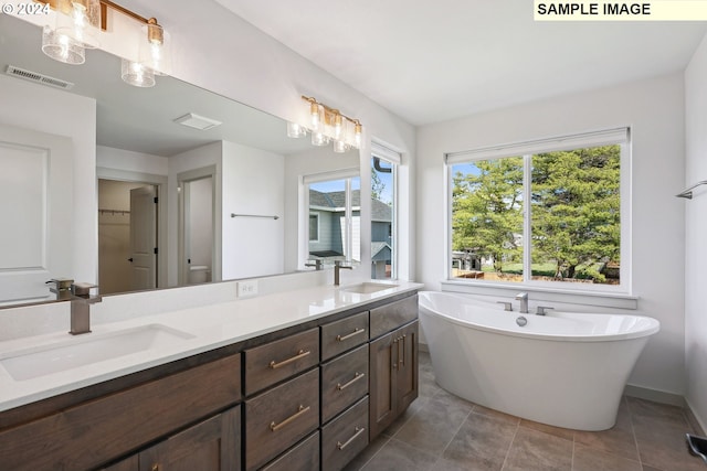 bathroom featuring a tub, tile patterned flooring, and vanity