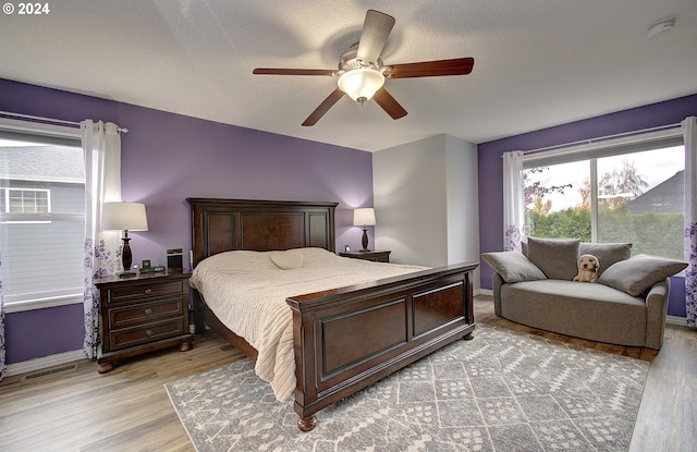 bedroom featuring a textured ceiling, light hardwood / wood-style flooring, and ceiling fan