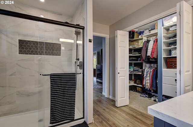 bathroom with wood-type flooring and a shower with shower door