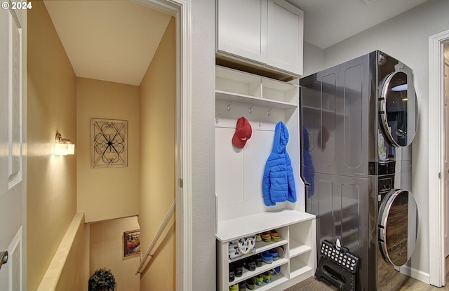 mudroom featuring stacked washer / drying machine and light wood-type flooring