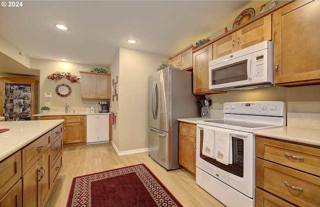 kitchen featuring white appliances and light hardwood / wood-style flooring