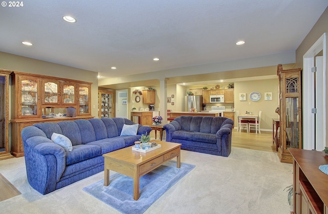 living room with light hardwood / wood-style flooring and decorative columns