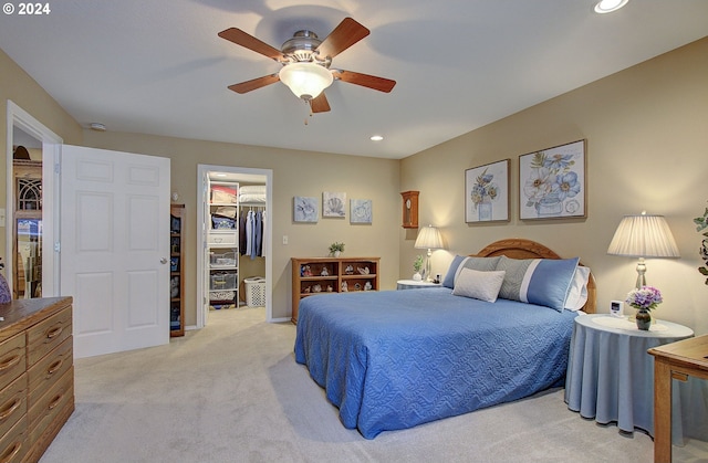 carpeted bedroom featuring a closet, a walk in closet, and ceiling fan