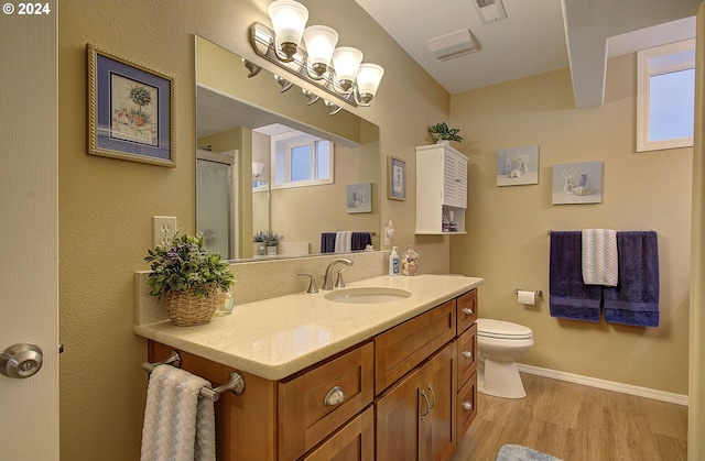 bathroom featuring an enclosed shower, vanity, hardwood / wood-style flooring, and toilet