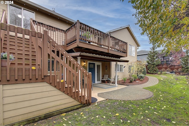 back of property featuring a deck, a yard, and a patio