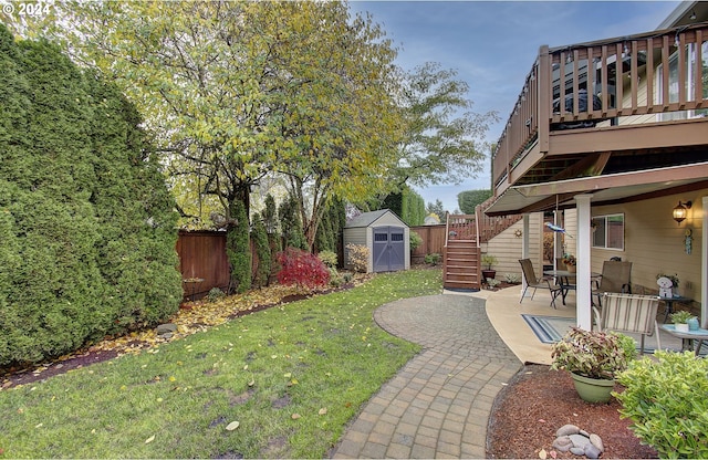 view of yard featuring a shed, a deck, and a patio area