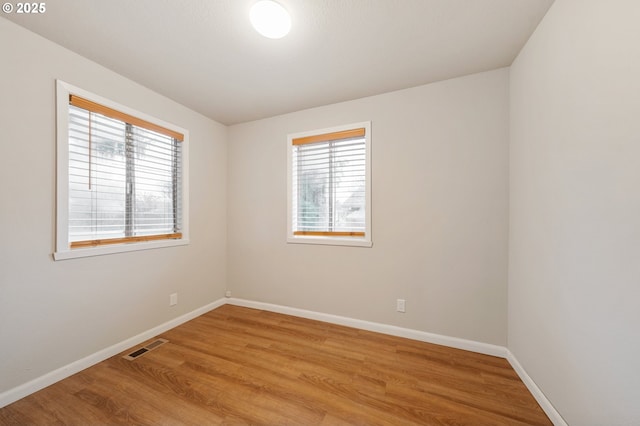 unfurnished room with plenty of natural light and light hardwood / wood-style floors