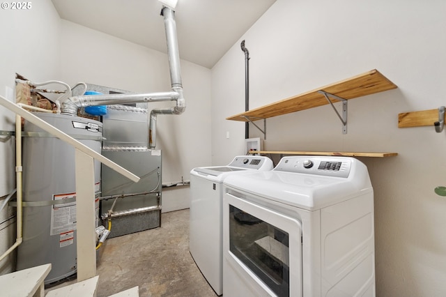 clothes washing area featuring water heater and washer and dryer