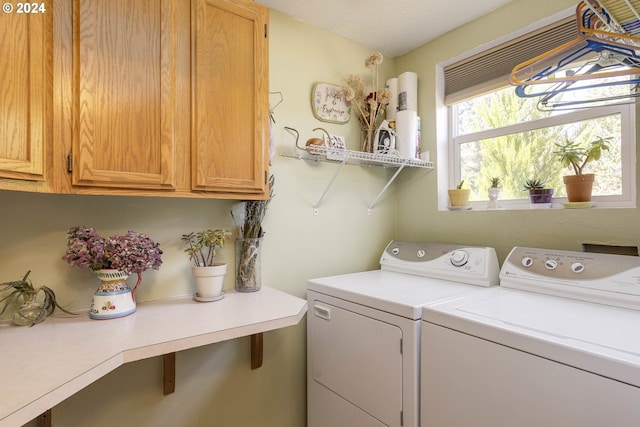 laundry area featuring separate washer and dryer and cabinets