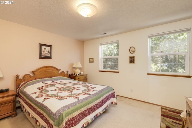 bedroom featuring a textured ceiling and carpet