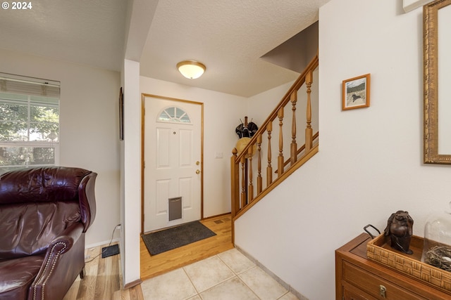 foyer with a textured ceiling and light hardwood / wood-style floors