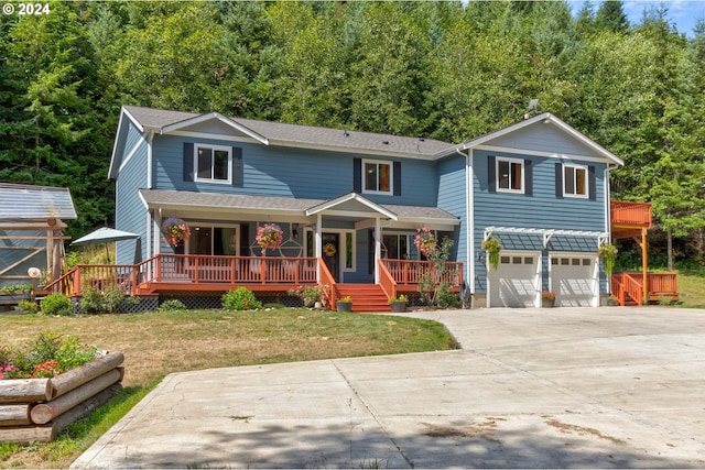 view of front property with a garage, a front yard, and covered porch