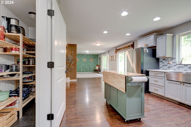 kitchen featuring hardwood / wood-style flooring, plenty of natural light, and backsplash