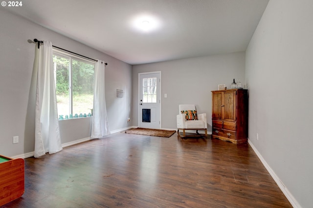 living area featuring baseboards and dark wood finished floors