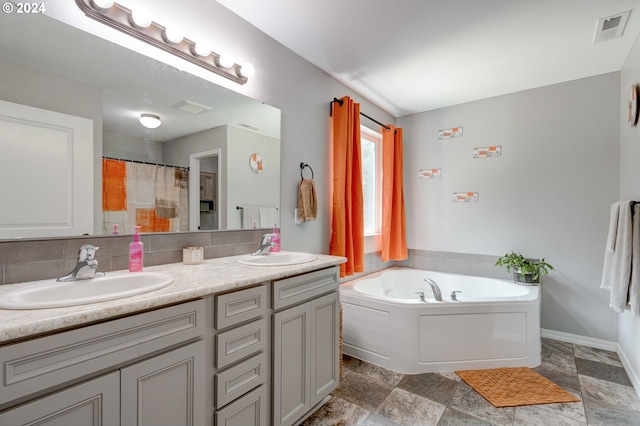 bathroom with plus walk in shower, tile patterned floors, tasteful backsplash, and vanity