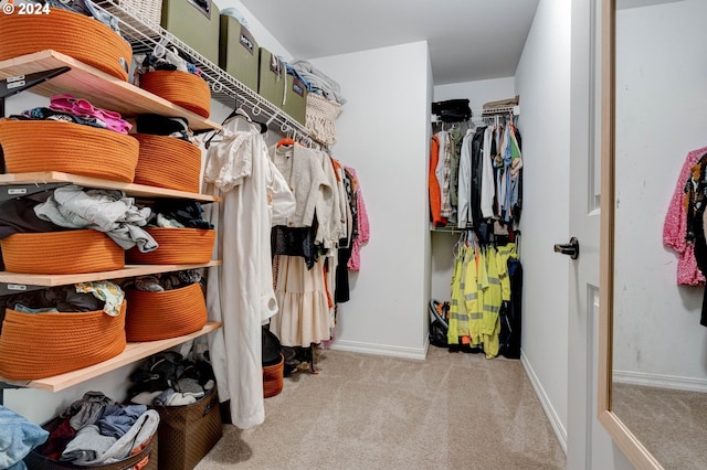 walk in closet featuring light carpet