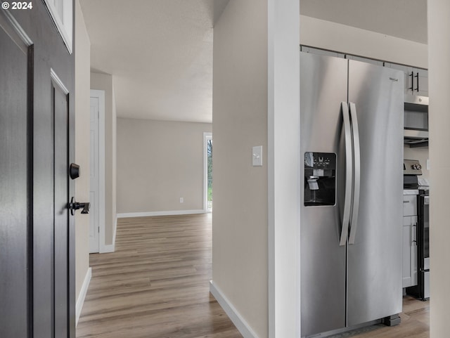 kitchen with appliances with stainless steel finishes and light hardwood / wood-style floors