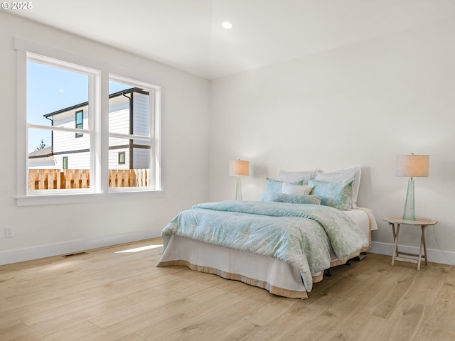 bedroom featuring baseboards, wood finished floors, visible vents, and recessed lighting