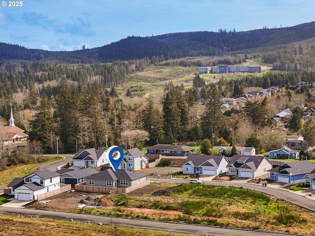 birds eye view of property with a residential view, a view of trees, and a mountain view